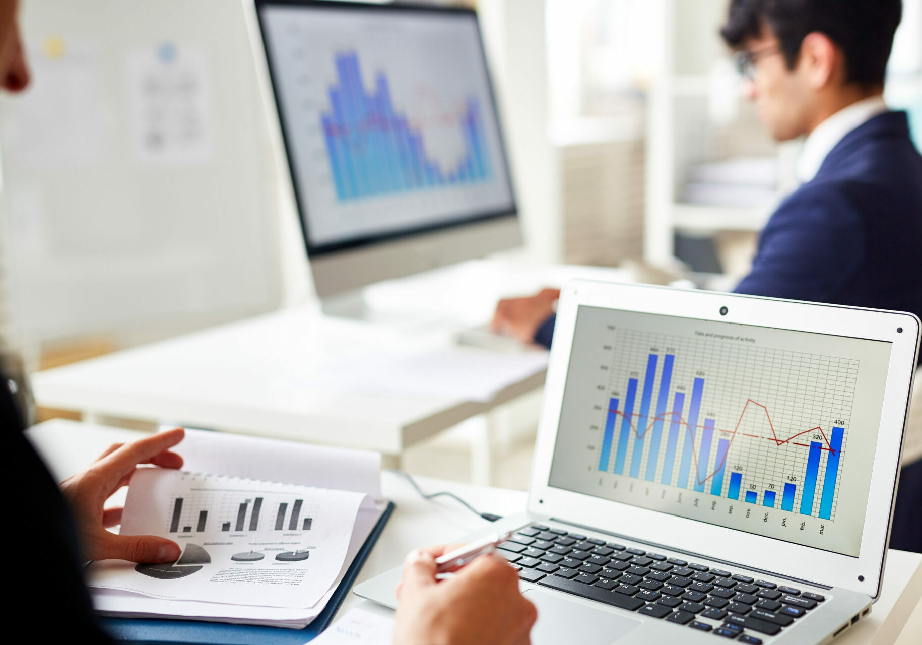 Statistics chart on laptop display and trader analyzing the data