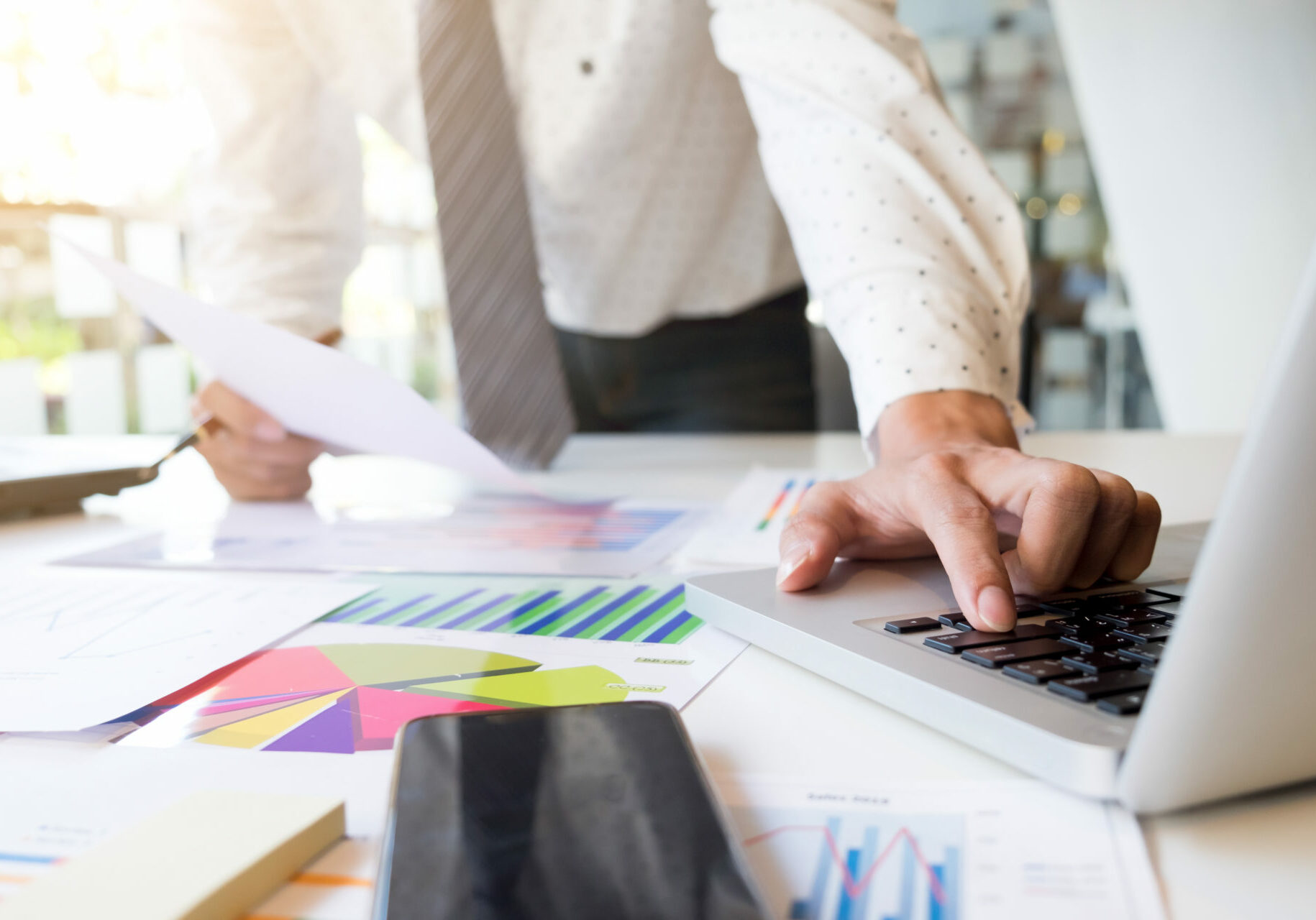 Startup businessman working with business documents on office table with graph financial diagram.