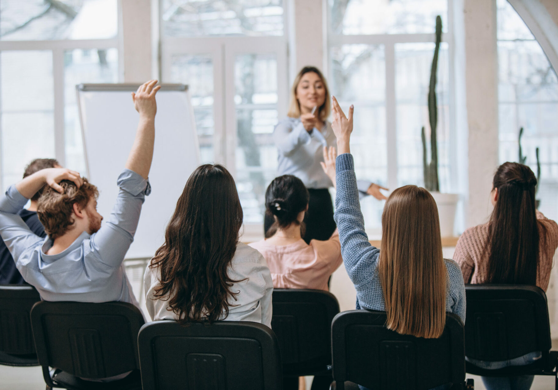 Increase. Female speaker giving presentation in hall at university workshop. Audience or conference hall. Rear view of unrecognized participants. Scientific, business event, training. Education